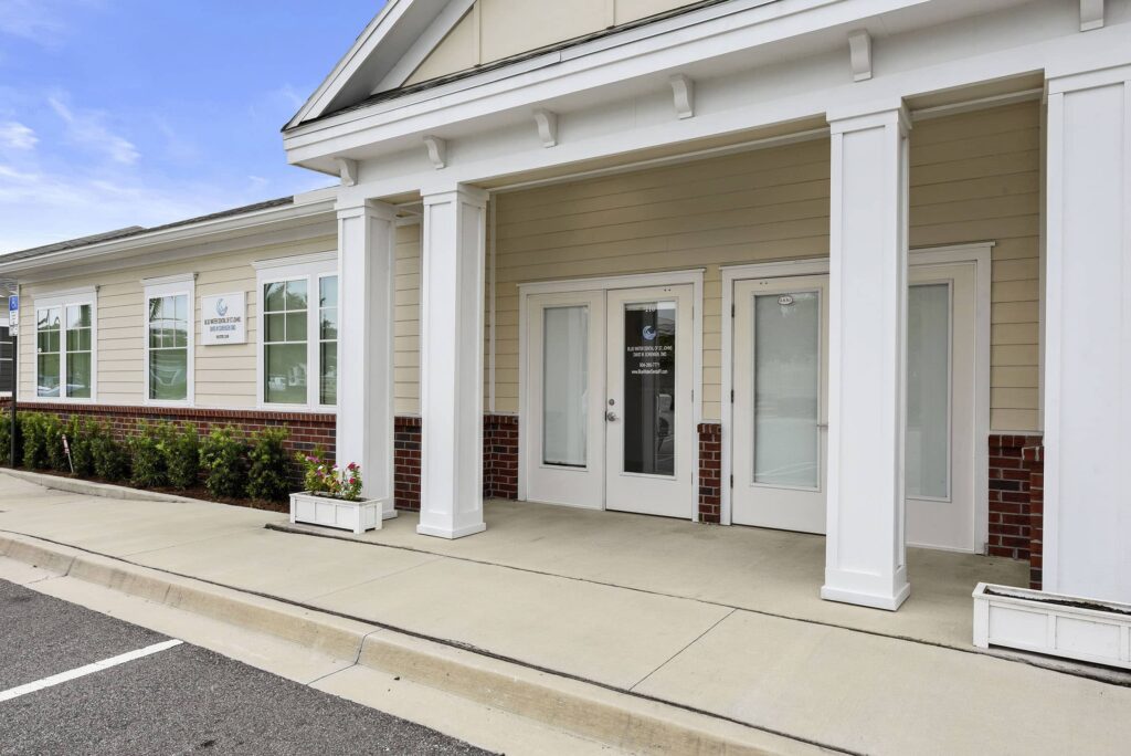 Entrance to the Blue Water Dental of St. Johns office with white columns and glass doors