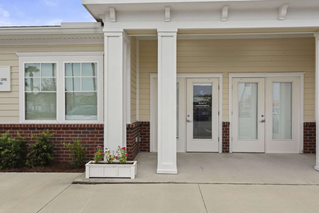 Columned front porch and entrance doors of the Blue Water Dental office