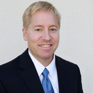 Dr. David W. Sorensen, DMD, smiling in a dark suit and blue tie