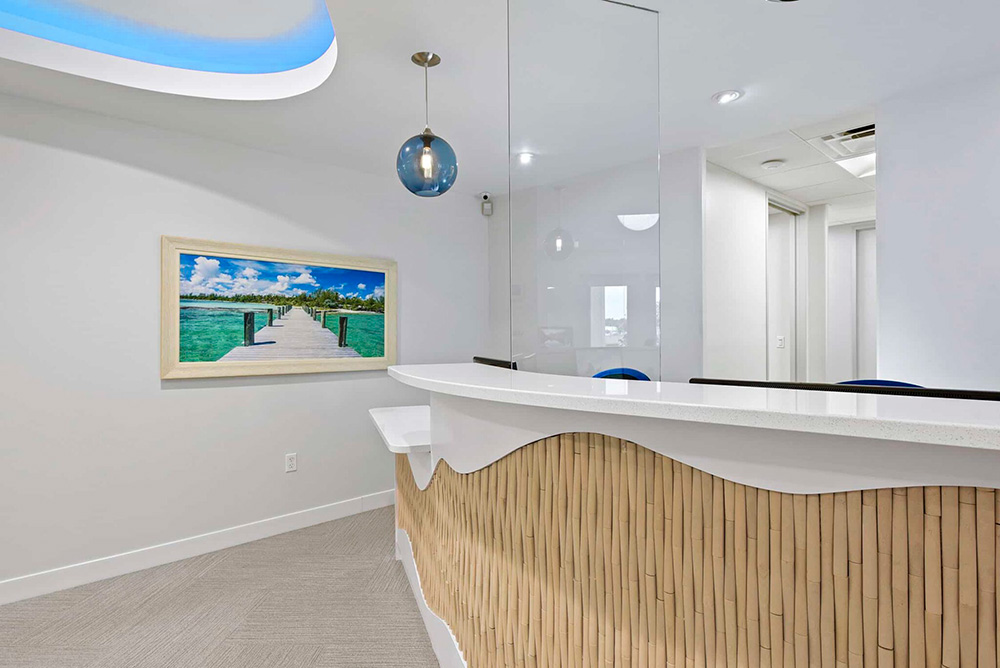 Front desk at Blue Water Dental with a wave-shaped counter and beach artwork