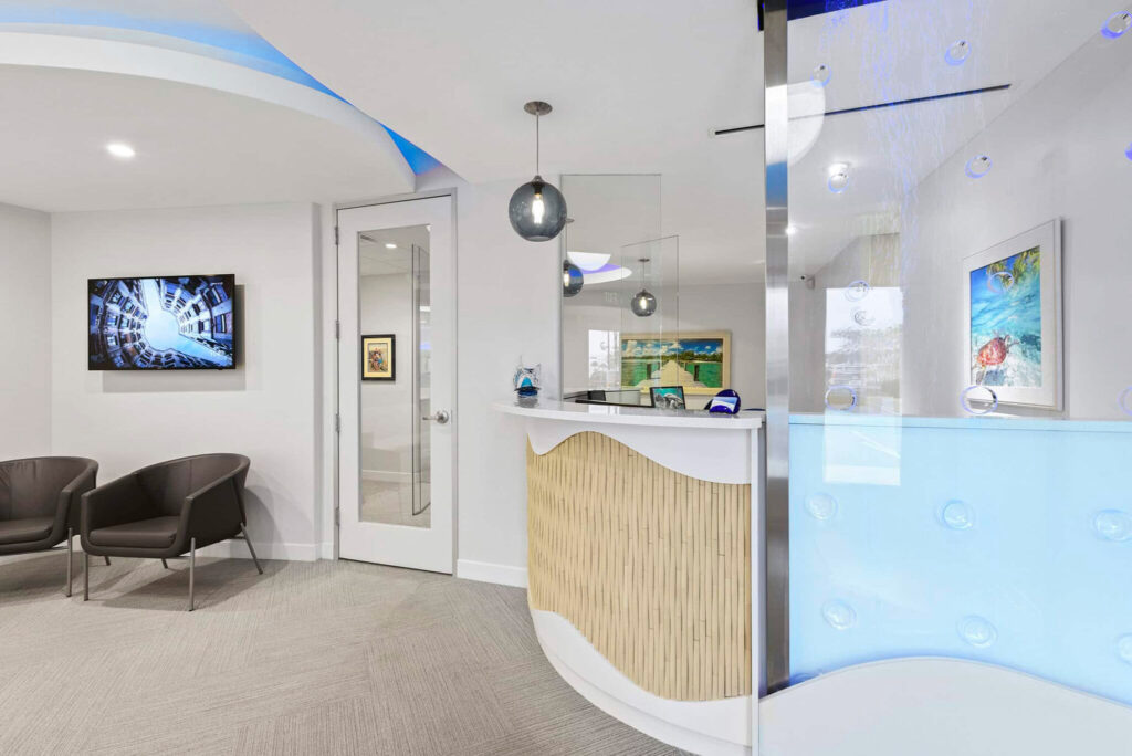 Reception desk and waiting chairs with a wall TV and glass partition