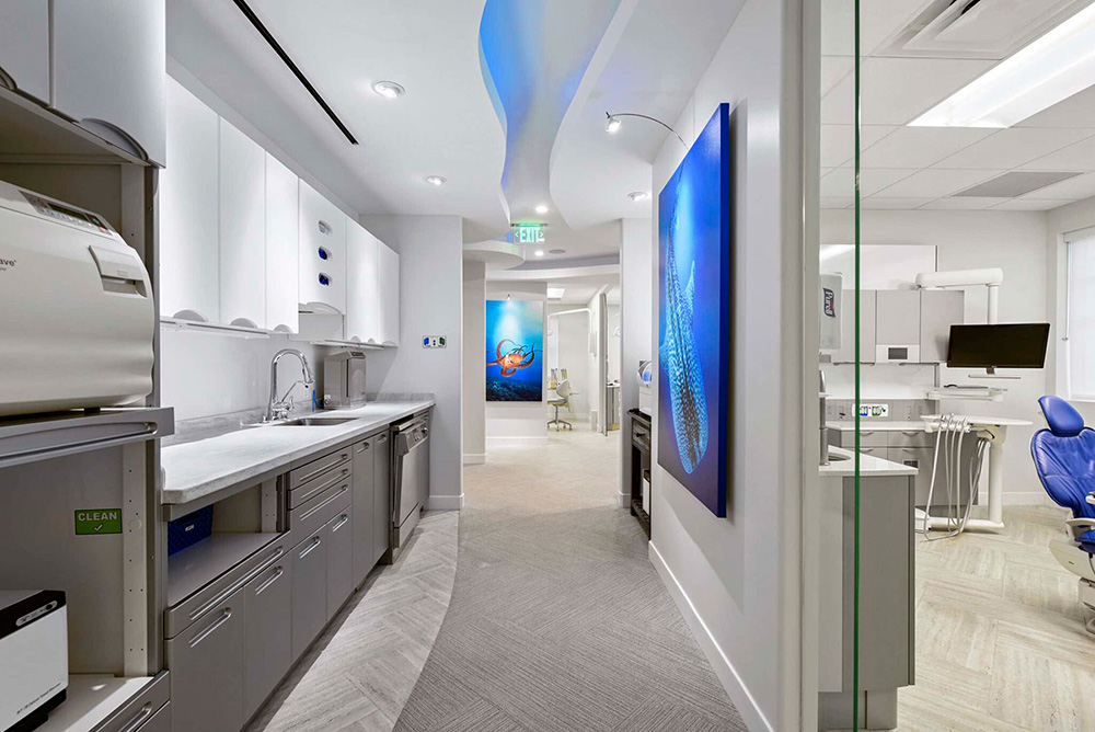 Hallway with a sterilization station and artwork leading to treatment rooms